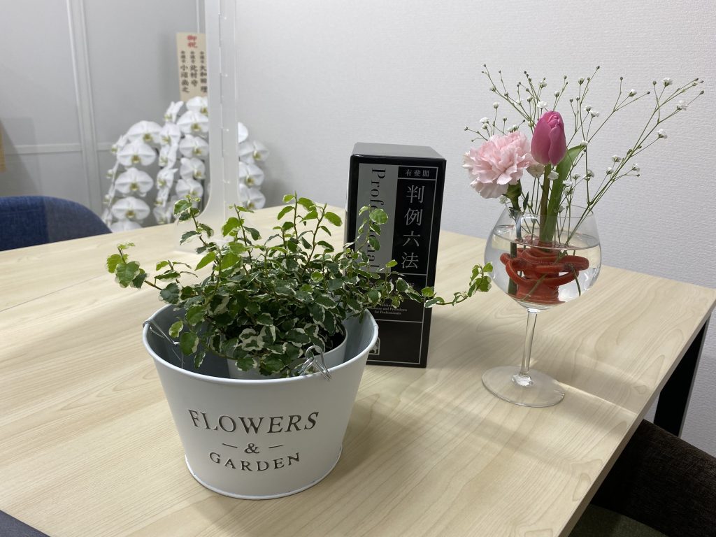 事務所に飾られた花と判例六法